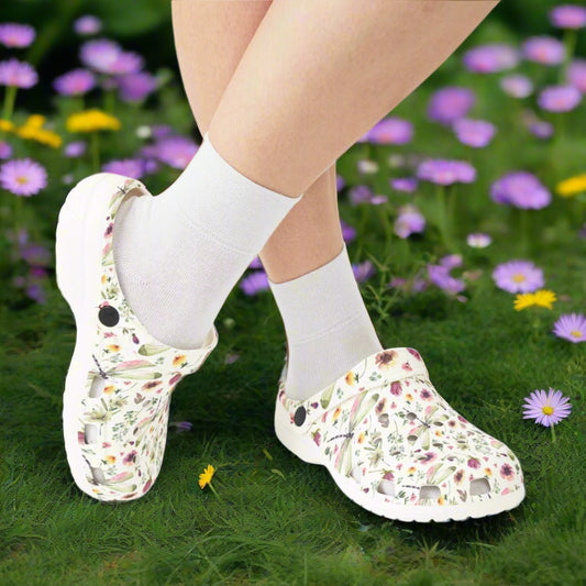 Floral-patterned clogs worn with white socks on a white background