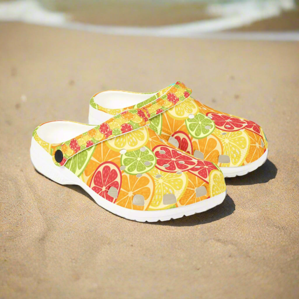 Pair of colorful clogs with fruit pattern on a white background