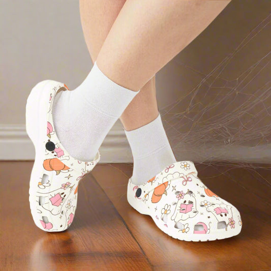 White clogs with cartoon designs worn with white socks on a white background