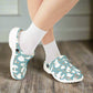 Clogs with a cartoon character pattern worn with white socks on a white background