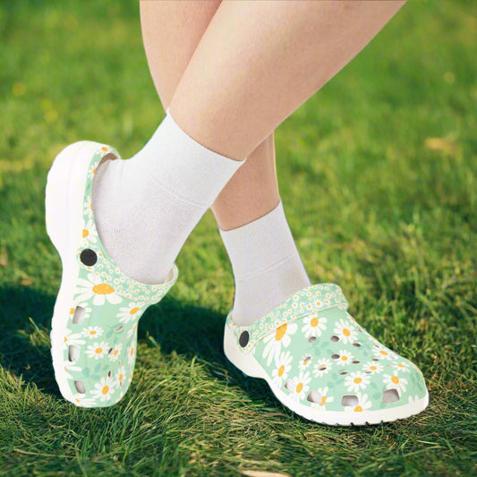 Green floral clogs worn with white socks on a white background
