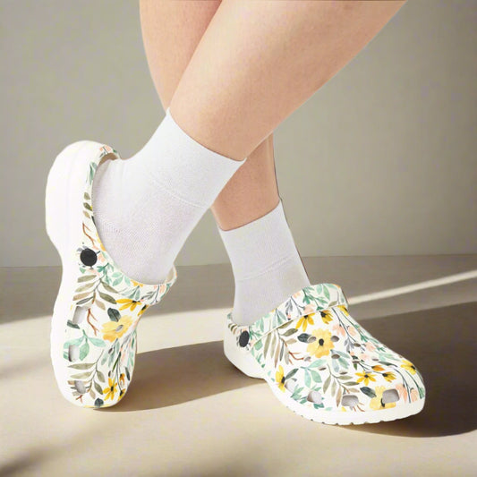Floral-patterned clogs worn with white socks on a white background