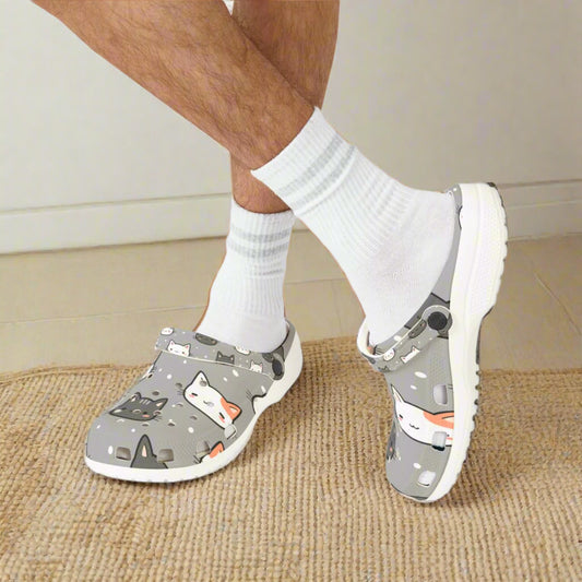 Gray clogs with cat design worn with white socks on a white background