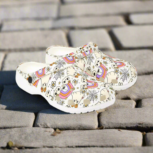 Pair of white clogs with colorful unicorn and rainbow pattern on a white background
