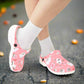 Pink clogs with ghost design worn with white socks on a white background