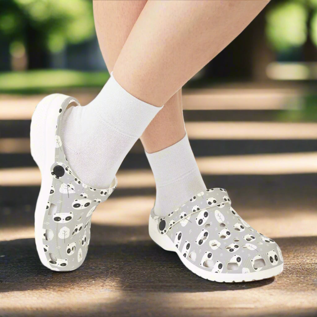 Gray clogs with black polka dots worn with white socks on a white background