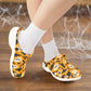Orange shoes with Halloween-themed design worn with white socks on a white background