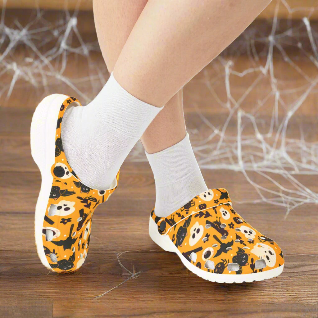 Orange shoes with Halloween-themed design worn with white socks on a white background