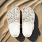 Pair of floral-patterned slippers on a white background