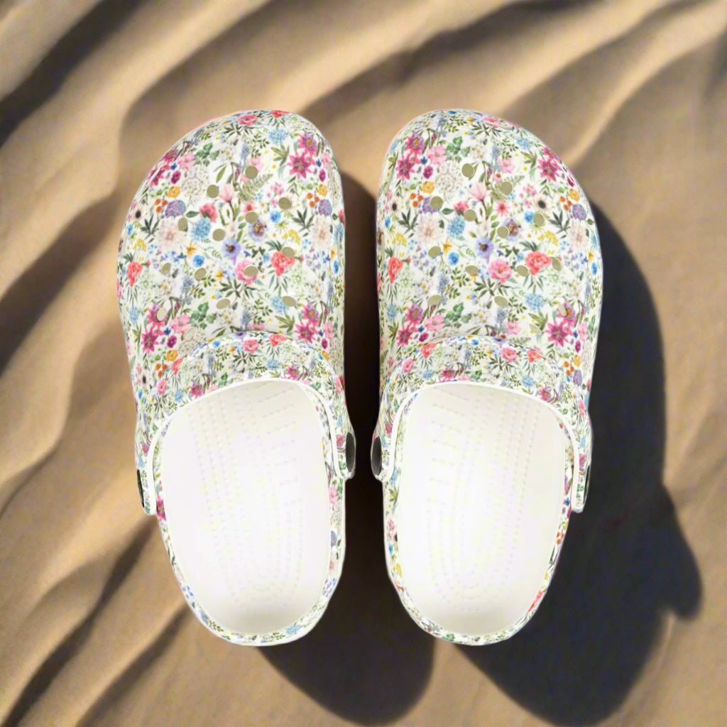 Pair of floral-patterned slippers on a white background
