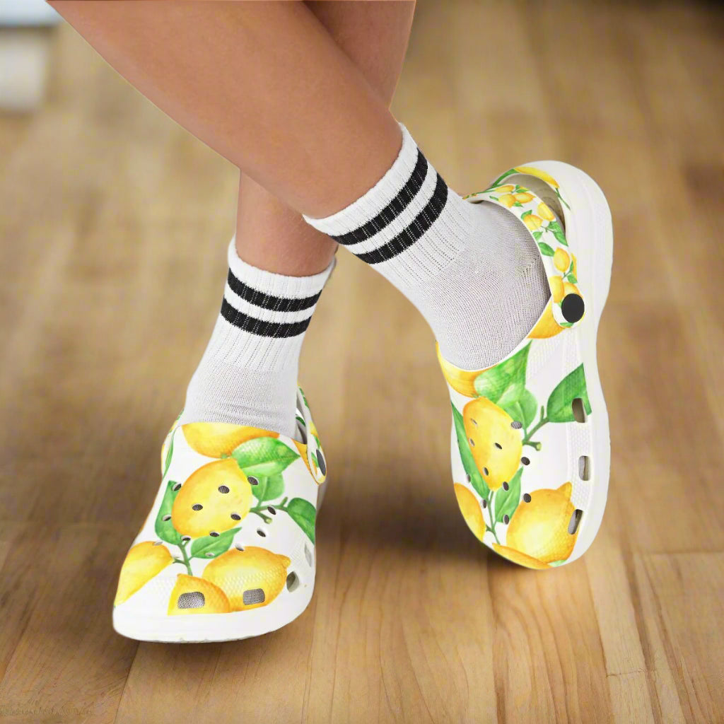 White shoes with lemon design worn with white socks on a white background