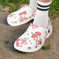 White clogs with pink floral design worn by a child on a white background