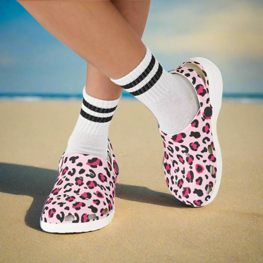 Pink leopard print slip-on shoes with white socks and black stripes on a white background
