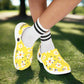 Yellow floral shoes worn with white socks on a white background