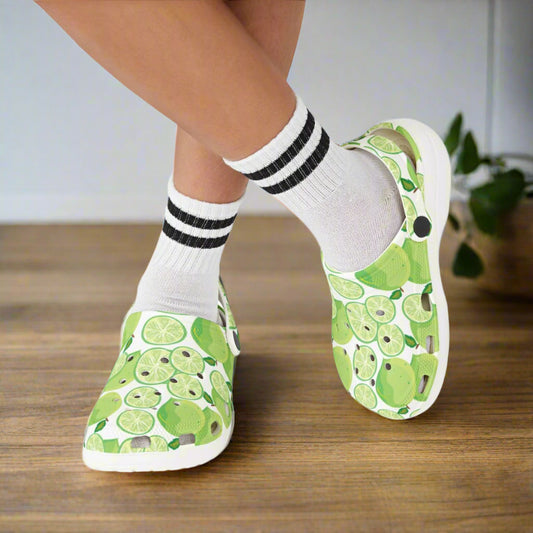 Green fruit-patterned shoes worn with white socks on a white background